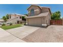 Lovely home with a well-manicured lawn, neutral exterior, and spacious driveway with brick accents at 1705 W Lark Dr, Chandler, AZ 85286