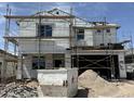 Two story home under construction with exposed insulation, scaffolding and dumpster in front at 17074 W Seldon Ln, Waddell, AZ 85355