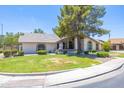 Well-kept single-story home showcasing desert landscaping, a lush lawn, and a large shade tree at 3611 E Dartmouth Cir, Mesa, AZ 85205