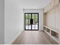Light-filled mudroom with hardwood floors, built-in storage, and large black grid window overlooking desert landscape at 3800 E Lincoln Dr # 54, Phoenix, AZ 85018