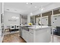 Bright kitchen with island seating, stainless steel sink, and sliding glass doors to the outdoor patio at 4302 E Cynthia St, Gilbert, AZ 85295