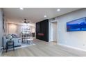 Open-concept living room with modern fireplace and light wood-look flooring at 4303 E Cactus Rd # 128, Phoenix, AZ 85032