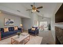 Spacious living room featuring vaulted ceilings, neutral paint, ceiling fans, and a cozy fireplace at 522 W Dennis Ct, Tempe, AZ 85283