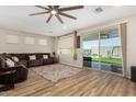 Spacious living room featuring wood floors, a ceiling fan, and a sliding door to the backyard at 5516 N 193Rd Ave, Litchfield Park, AZ 85340