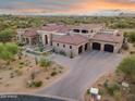 Expansive home featuring desert landscaping, red tile roof, and a spacious driveway leading to a 3-car garage at 7254 E Sonoran Trl, Scottsdale, AZ 85266