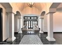 Grand foyer with soaring ceilings, columns, tile floors, and views to the outdoor living area at 7254 E Sonoran Trl, Scottsdale, AZ 85266