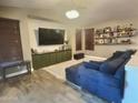 The living room features a large television, shelves, and plush sofa at 7313 S 25Th S Dr, Phoenix, AZ 85041