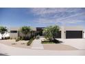 Modern home showcasing a two-car garage, desert landscaping, and a welcoming front entrance at 8528 E Clydesdale Trl, Scottsdale, AZ 85258