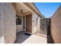Charming front entry with a secure gate, stone accents, and covered porch adding curb appeal and security at 874 E Lamonte St, San Tan Valley, AZ 85140
