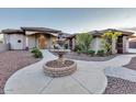Stately home with a circular driveway, decorative fountain, and manicured landscaping, offering an impressive entrance at 9183 W Shamel Ash Rd, Peoria, AZ 85383