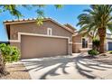 View of the front exterior of the home, with a driveway, garage, and a mature palm tree at 9465 W Tonopah Dr, Peoria, AZ 85382