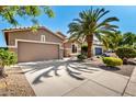 Front exterior showcasing a two-car garage, desert landscaping, and mature trees at 9465 W Tonopah Dr, Peoria, AZ 85382