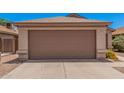 Attached single car garage featuring a brown door and concrete driveway at 105 W Monona Dr, Phoenix, AZ 85027