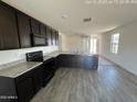 Modern kitchen featuring granite countertops, stainless steel appliances, and wood-look floors at 13142 E Aster Ln, Florence, AZ 85132