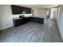 Stylish kitchen featuring granite countertops, stainless steel appliances, and wood-look floors at 13142 E Aster Ln, Florence, AZ 85132