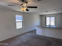 Bright open-concept living room featuring plush carpeting and a kitchen counter with granite countertops at 13142 E Aster Ln, Florence, AZ 85132