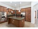 Gourmet kitchen features stainless appliances, spacious center island, and ample cabinet space at 14436 W Ventura St, Surprise, AZ 85379