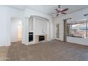 Cozy living room features fireplace, ample natural light, and access to the backyard at 14436 W Ventura St, Surprise, AZ 85379