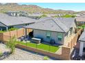 Cozy backyard with artificial grass, hot tub, brick fence, and outdoor seating area perfect for relaxation at 16528 W Pedro Ln, Goodyear, AZ 85338