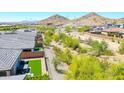 Aerial view of backyard featuring green turf, stone landscaping, and a fence line bordering the community area at 16528 W Pedro Ln, Goodyear, AZ 85338