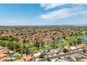 Wide aerial view of the neighborhood with homes, golf course, ponds, and scenic mountain views at 18854 N 73Rd Dr, Glendale, AZ 85308