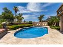 Beautiful pool area surrounded by lush landscaping and a spacious travertine patio at 18854 N 73Rd Dr, Glendale, AZ 85308