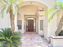 Inviting front entrance featuring a decorative arched entryway, custom wood door and red clay tile at 2053 E Clubhouse Dr, Phoenix, AZ 85048