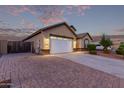 Beautiful home with a brick paved driveway and a pristine two-car garage with a manicured lawn at 2236 W Aston Dr, San Tan Valley, AZ 85144