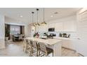 Open-concept kitchen with large island, pendant lighting, and stainless steel appliances at 3123 S 155Th Ln, Goodyear, AZ 85338