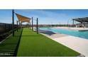 Community swimming pool with artificial turf and covered lounge areas at 3123 S 155Th Ln, Goodyear, AZ 85338