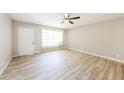 Bright living room with modern light wood flooring, a ceiling fan, and a large window for natural light at 3238 W Rose Ln, Phoenix, AZ 85017