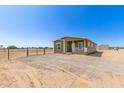 Inviting home featuring a well-maintained exterior with a cozy front porch and ample natural light at 32650 N 223Rd Dr, Wittmann, AZ 85361