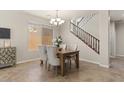 Cozy dining area with neutral tones, elegant chandelier and convenient access to a staircase at 5060 S Clancy --, Mesa, AZ 85212