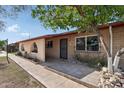 Inviting single-story home with brick accents and an arched entryway, framed by a mature tree and walkway at 6739 N 16Th St # 17, Phoenix, AZ 85016