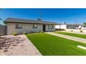 Inviting home exterior with a green lawn, paved walkway, and mature landscaping at 915 E Commonwealth Pl, Chandler, AZ 85225