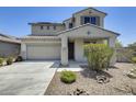 Charming two-story home featuring a tile roof, desert landscaping, and an attached two-car garage at 9805 W Caron Dr, Peoria, AZ 85345