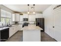 Modern kitchen with white cabinets, a center island, stainless steel appliances, and tile backsplash at 9805 W Caron Dr, Peoria, AZ 85345