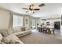 Open-concept living area with a comfortable couch, dining table, and an view of the modern kitchen at 9805 W Caron Dr, Peoria, AZ 85345