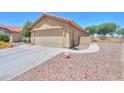 A desert landscaped driveway leads to the spacious two-car garage of this home at 103 S Birdie Way, Casa Grande, AZ 85194