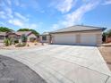 Attractive house showcasing an oversized driveway, three-car garage, and desert landscaping at 10501 W Wilshire Dr, Avondale, AZ 85392