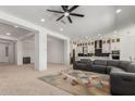 Spacious living area with open layout to kitchen, modern ceiling fan, and comfortable seating arrangement at 11015 E Texas Ave, Mesa, AZ 85212