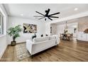 Bright living room features hardwood floors, modern fan, and open access to dining room and kitchen at 132 W Orchid Ln, Chandler, AZ 85225