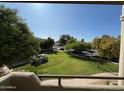 Balcony with view of the manicured lawn, mature trees, and ample parking, offering a serene and convenient living environment at 1825 W Ray Rd # 2082, Chandler, AZ 85224