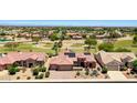 Stunning aerial view of a desert home with solar panels, golf course and scenic views at 19745 N Mountain Sage Ln, Surprise, AZ 85374