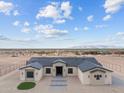 Expansive aerial view of a single-story home with a desert landscape and beautiful mountain views at 28848 W Grand Ave, Wittmann, AZ 85361