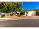 Charming home featuring desert landscaping, a two-car garage, and mature trees at 507 W Sweetwater Ave, Phoenix, AZ 85029