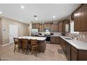 A spacious kitchen features stainless steel appliances, a center island with bar stool seating, and wooden cabinets at 5345 W Alta Mesa Ave, Laveen, AZ 85339