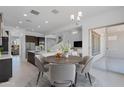Modern dining area with an adjacent open-concept kitchen and view of the home's contemporary staircase at 5917 N 83Rd Ln, Glendale, AZ 85305