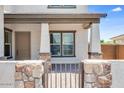 Inviting front porch and facade with stone columns and an iron gate leading to the entrance of the home at 5917 N 83Rd Ln, Glendale, AZ 85305