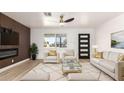 Elegant living room with white furniture, a modern ceiling fan, and a decorative accent wall at 6813 E Diamond St, Scottsdale, AZ 85257